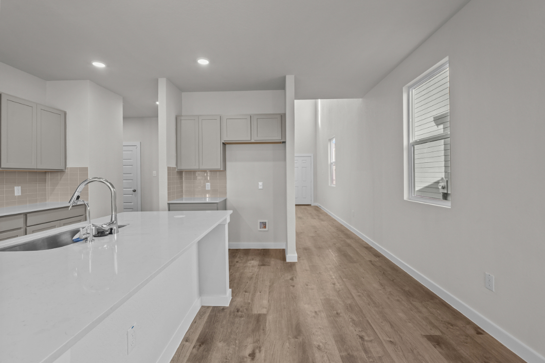 A kitchen with white cabinets.