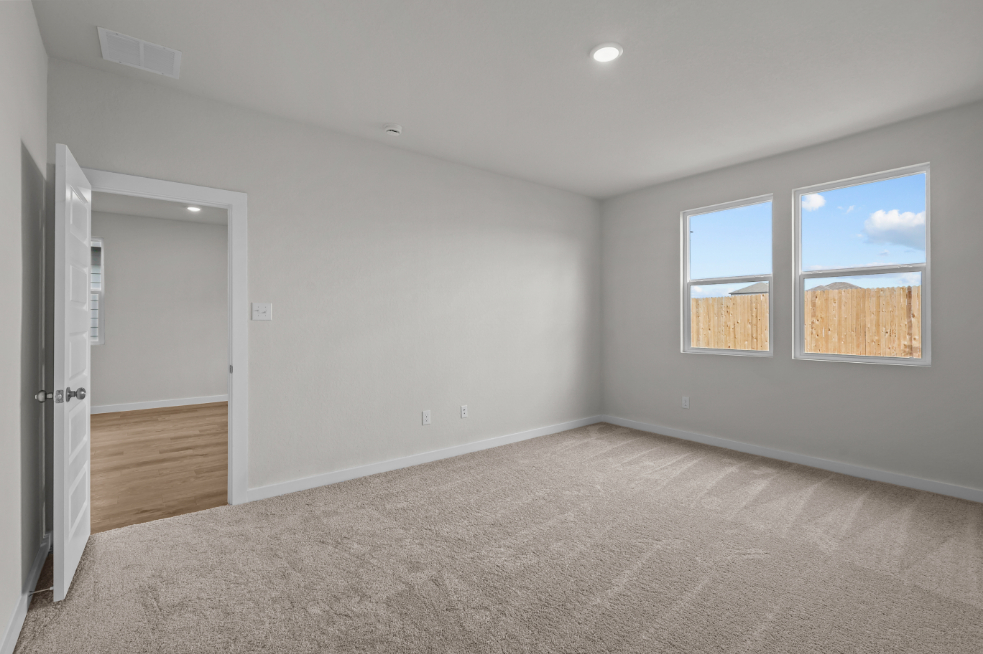 A room with a carpet and a window.