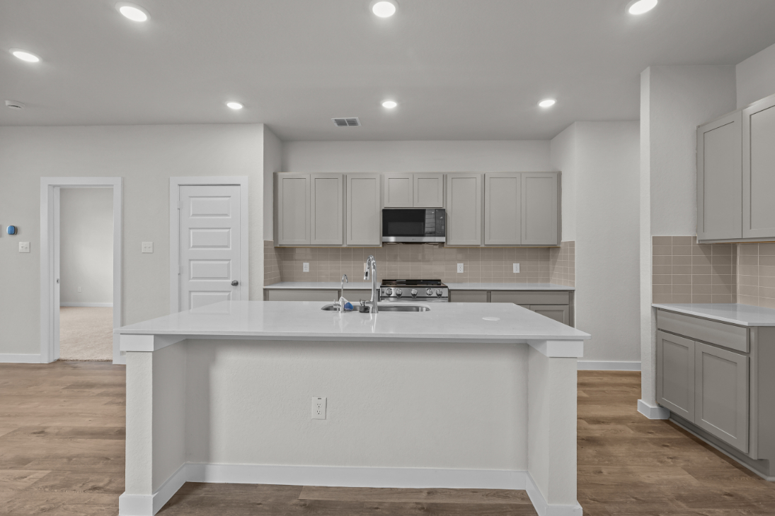 A kitchen with white cabinets.