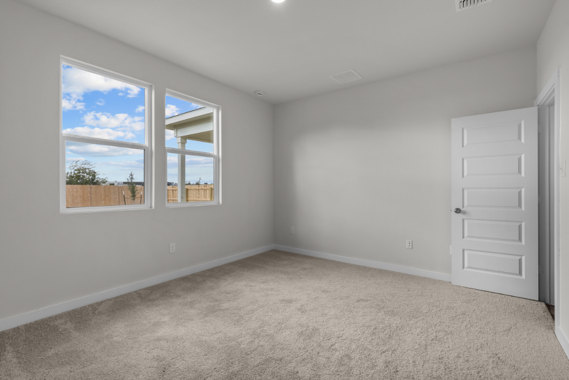 A room with a window and a door with a view of the ocean.