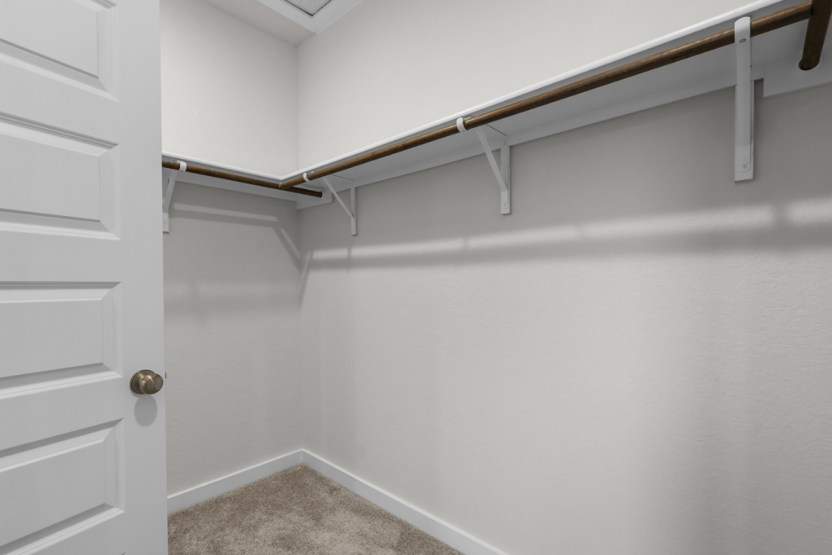 A white wall with a metal bar.