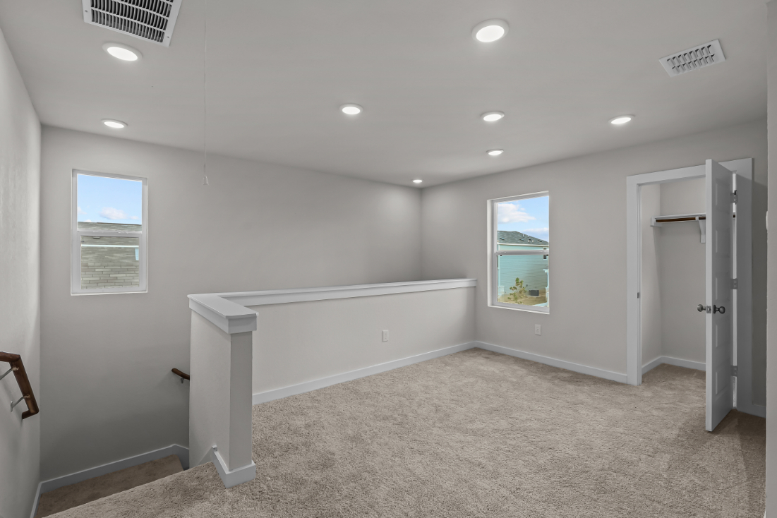 A room with a white couch and a window.