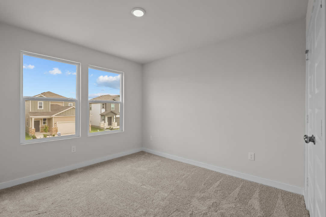 A room with a window and a carpet.