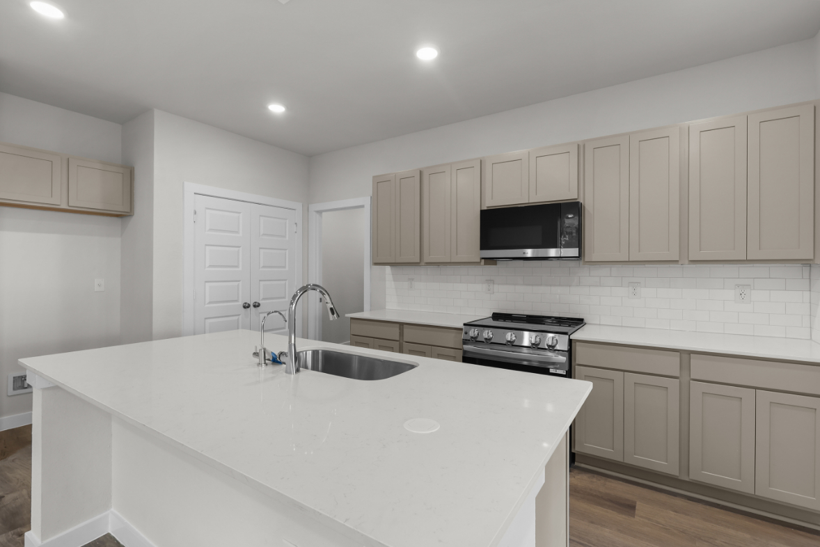 A kitchen with white cabinets.