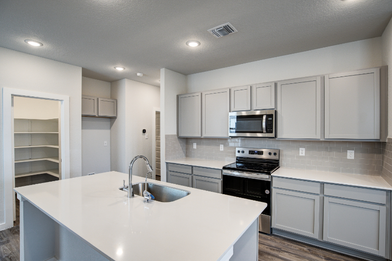 A kitchen with white cabinets.