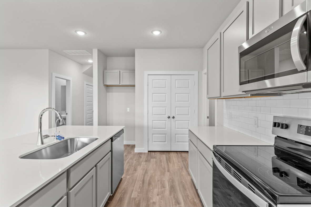 A kitchen with white cabinets.