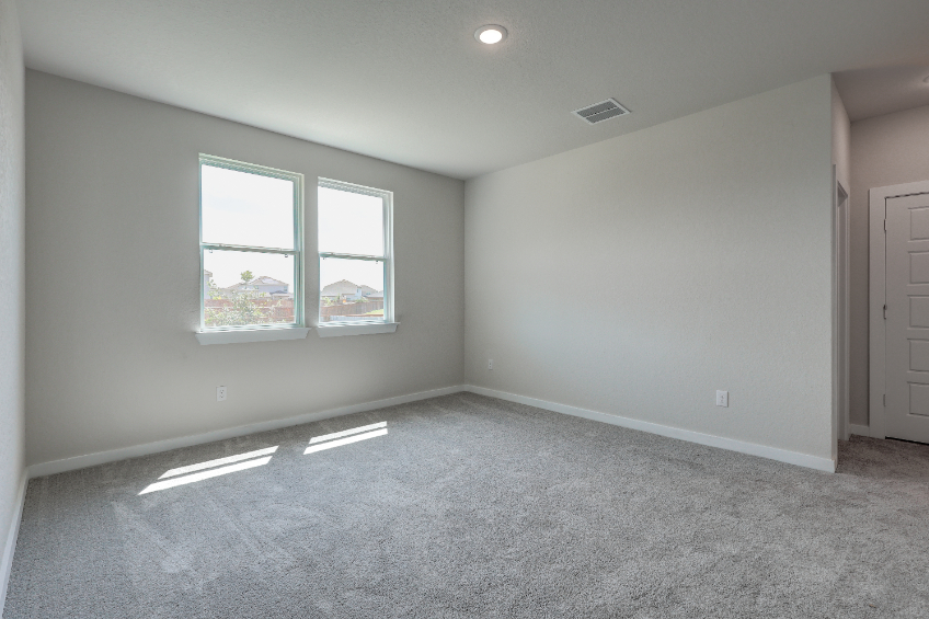 A room with a window and a carpet.
