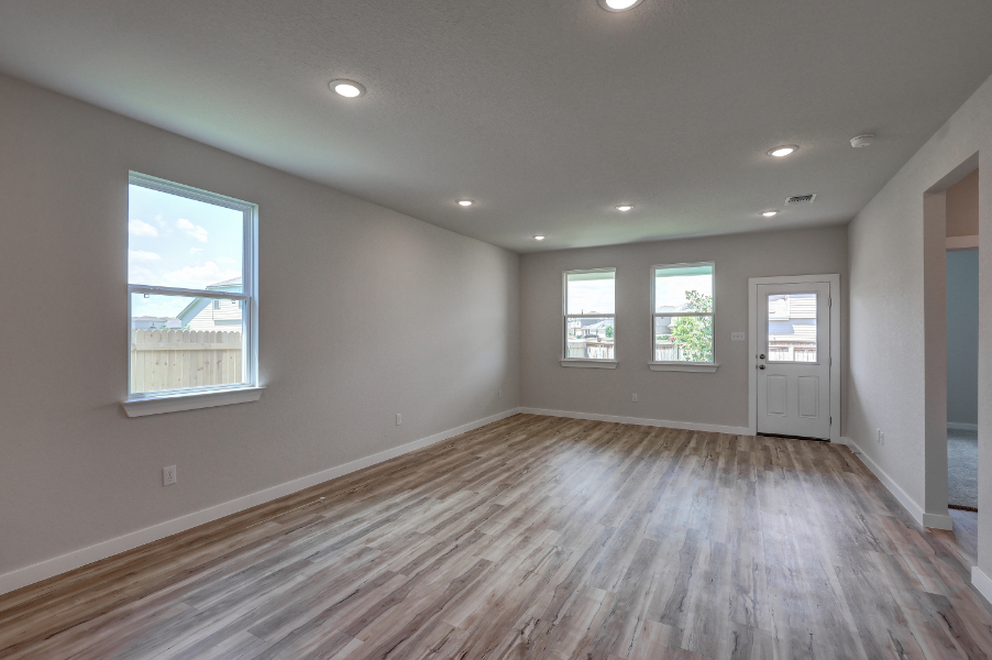 A room with a wood floor and windows.