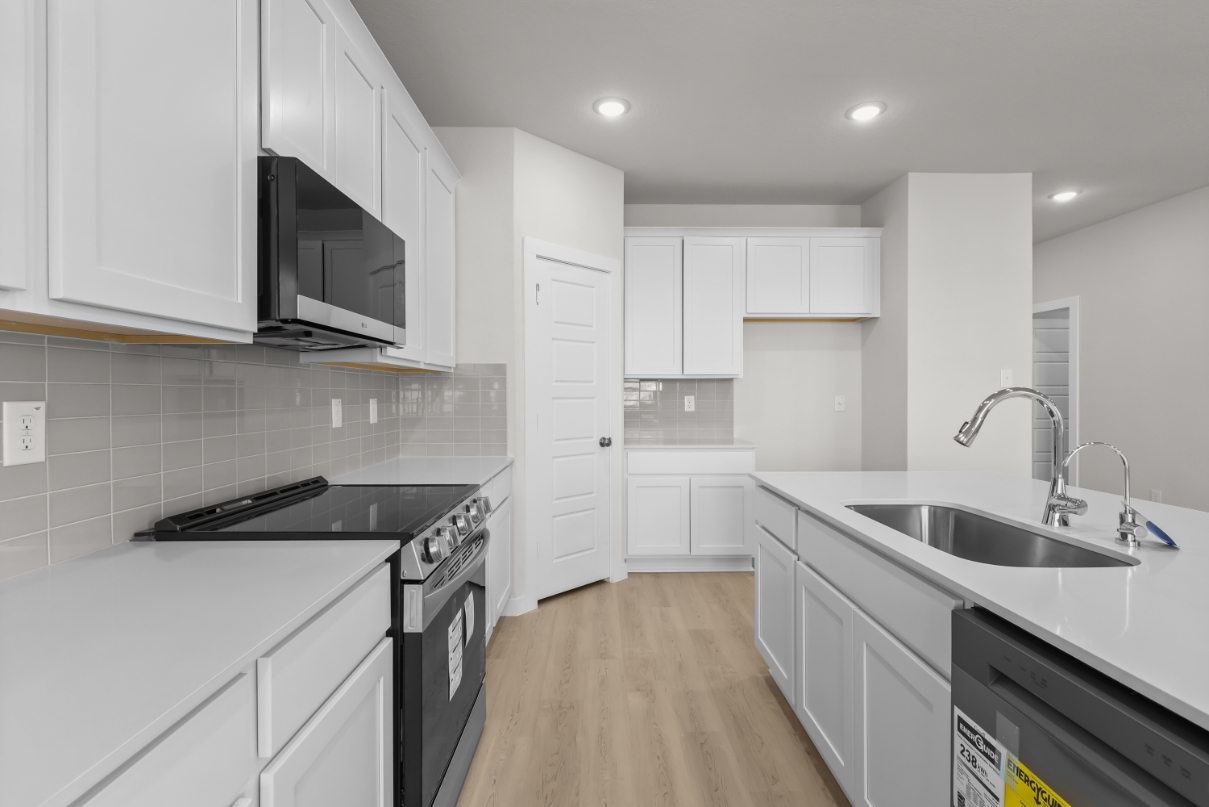 A kitchen with white cabinets.