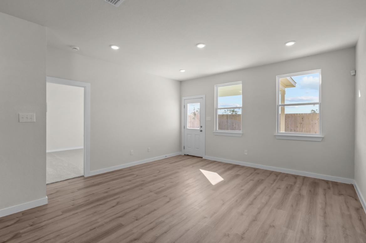 A room with a wood floor and a wood floor with a white door.