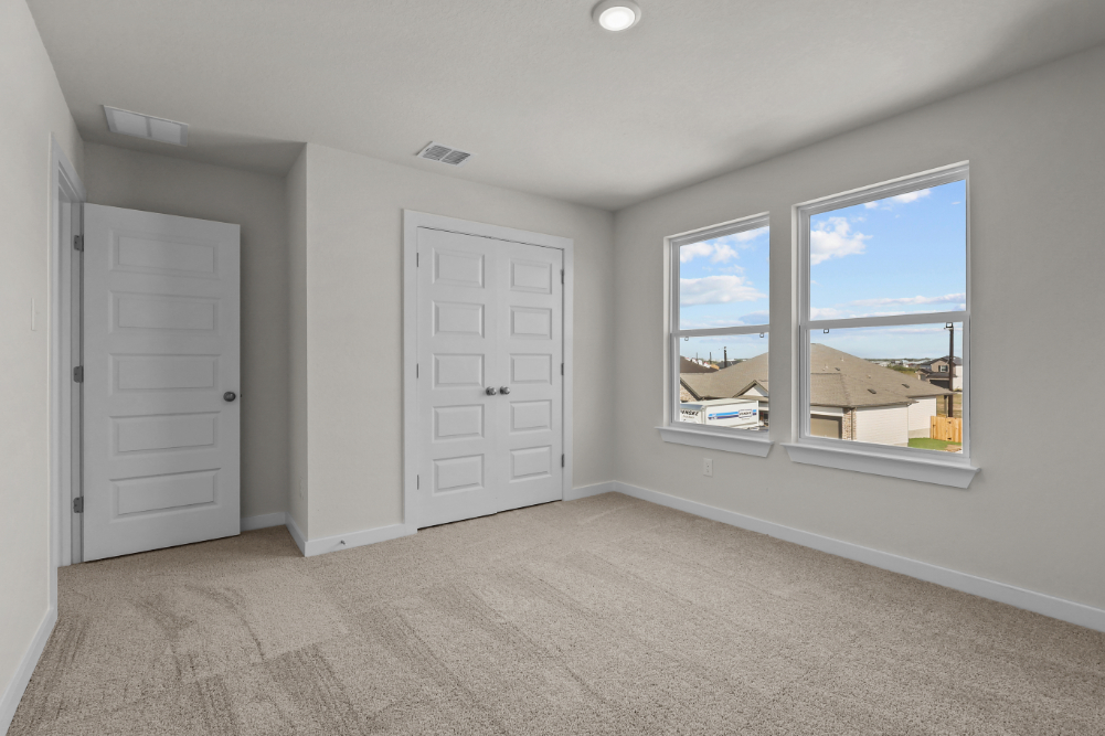 A room with white doors and a window with a view of the ocean.