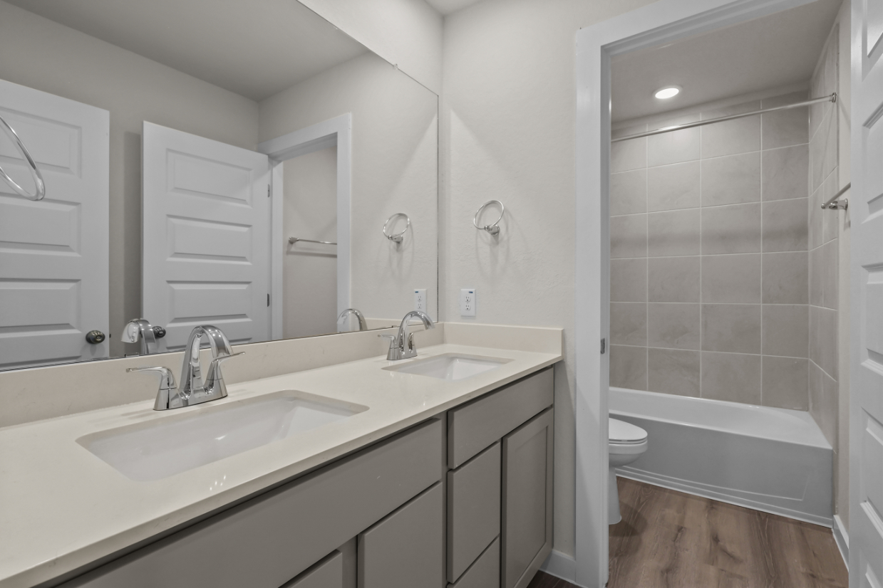 A bathroom with a sink and a shower unit.