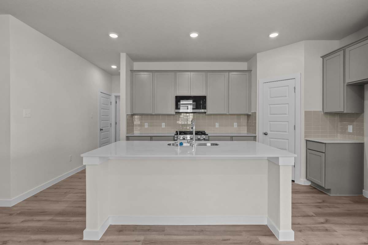 A kitchen with white cabinets.