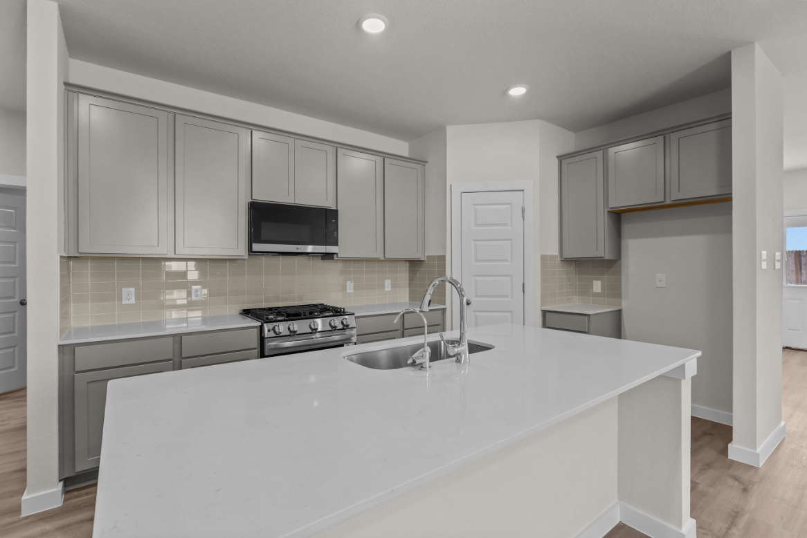 A kitchen with white cabinets.