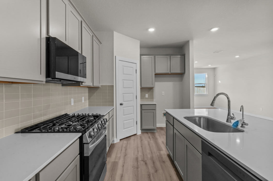 A kitchen with white cabinets.