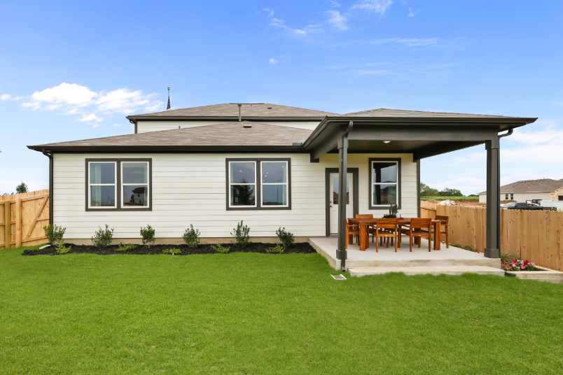 A house with a fence and lawn.
