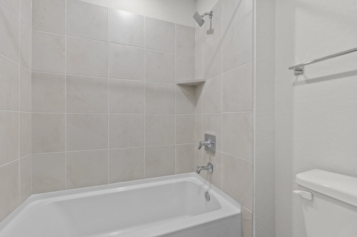 A bathroom with a bathtub and toilet.