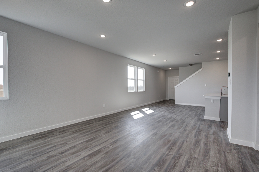 A room with a wood floor and windows.