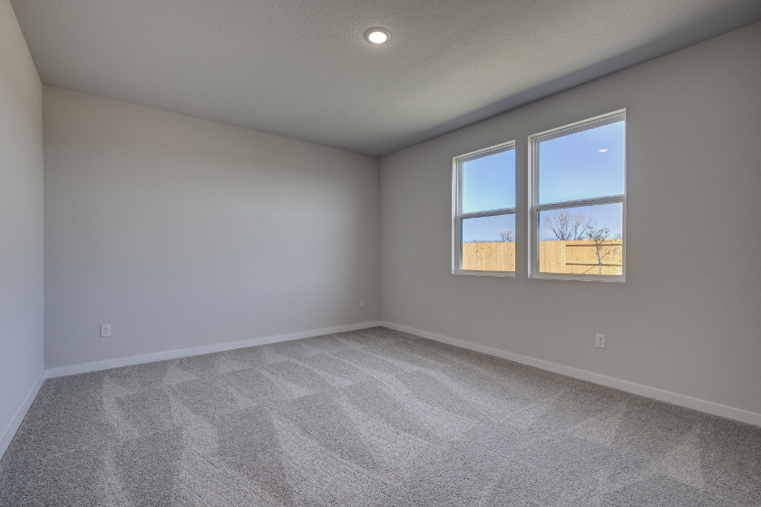 A room with a window and a carpet.