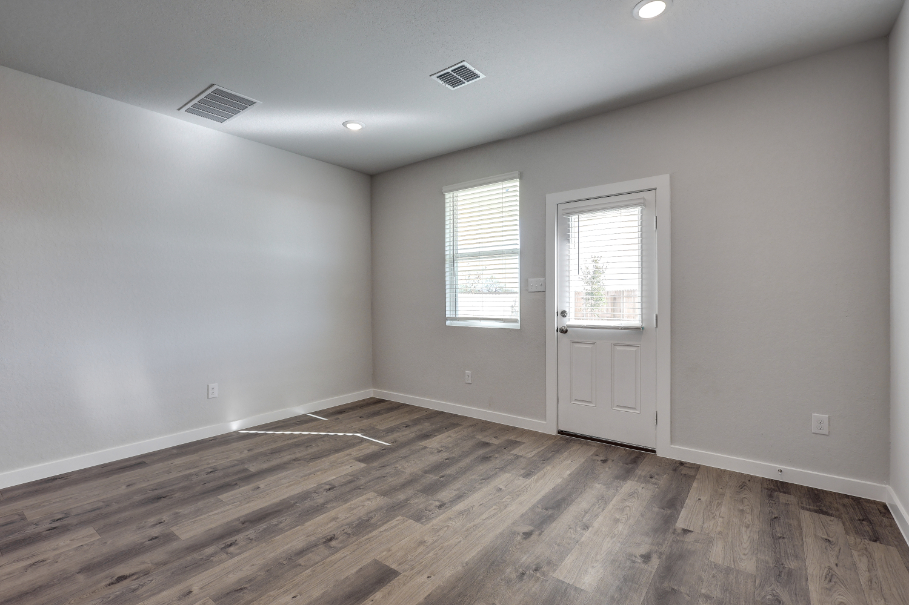 A room with a wood floor and white doors.