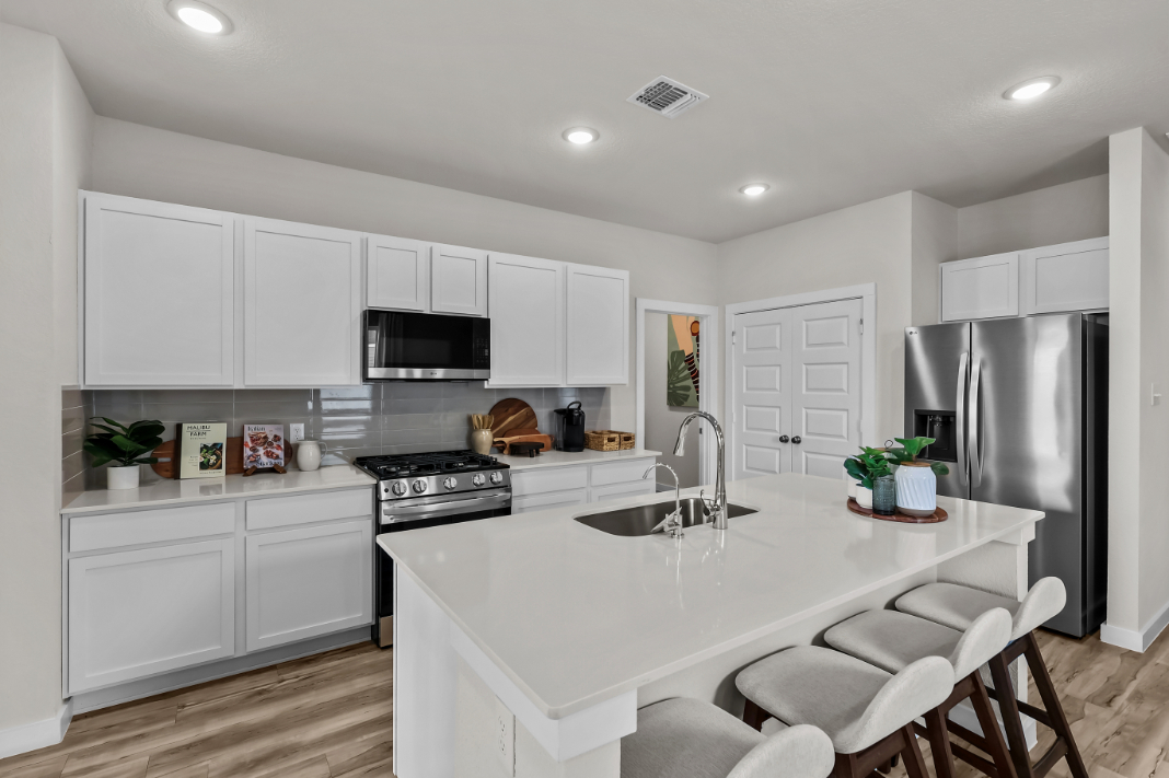 A kitchen with white cabinets.