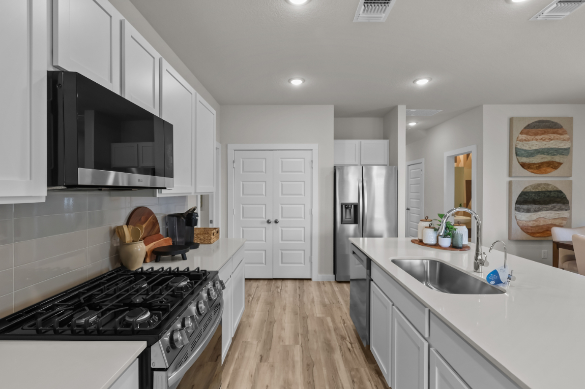 A kitchen with white cabinets.