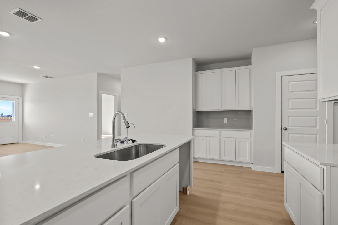 A kitchen with white cabinets.