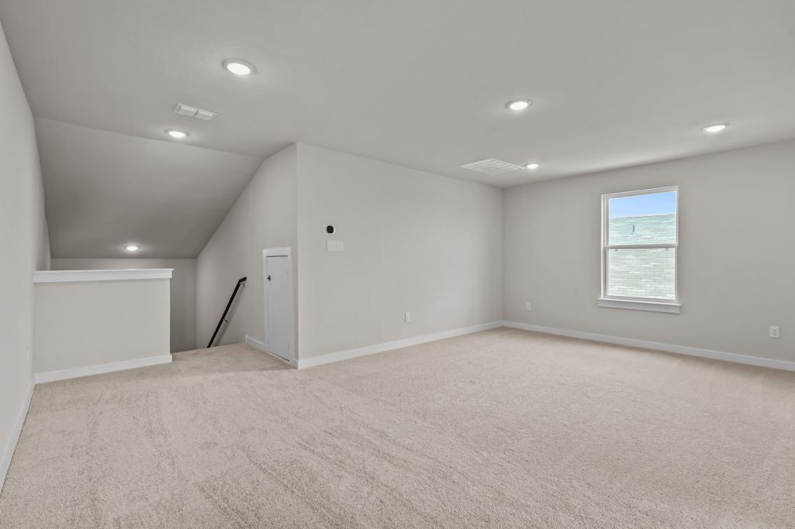 A room with a carpet and a white wall.