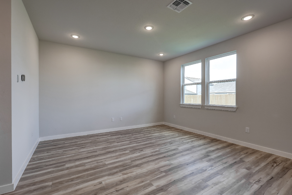 A room with a wood floor and windows.