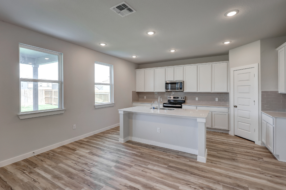 A kitchen with white cabinets.