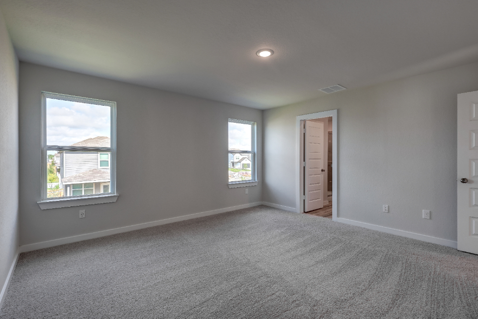 A room with a carpet and windows.