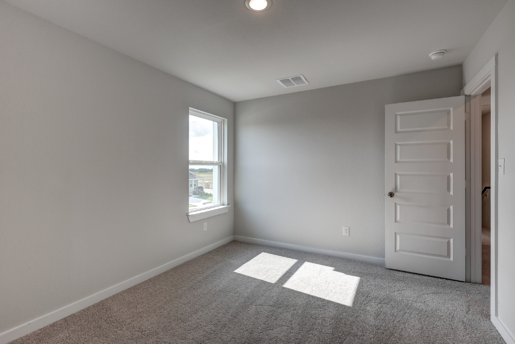 A room with white walls and a window.