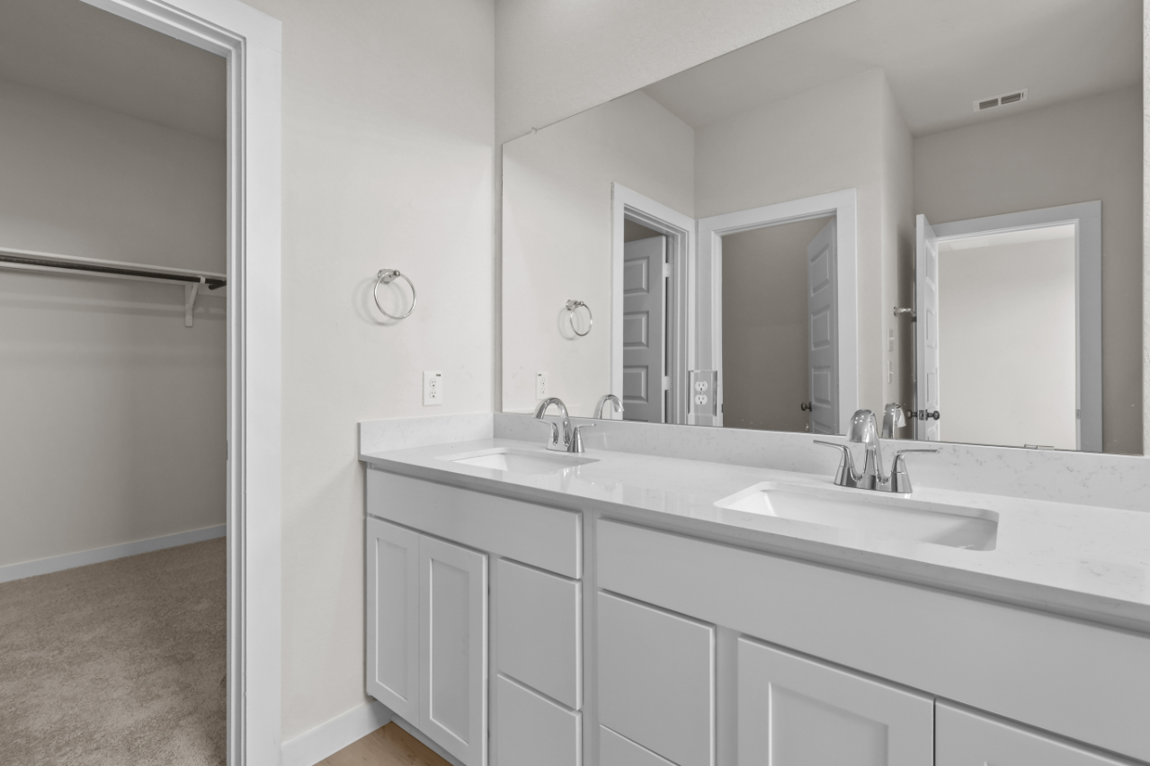 A bathroom with white cabinets.
