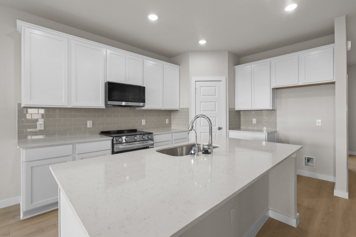 A kitchen with white cabinets.