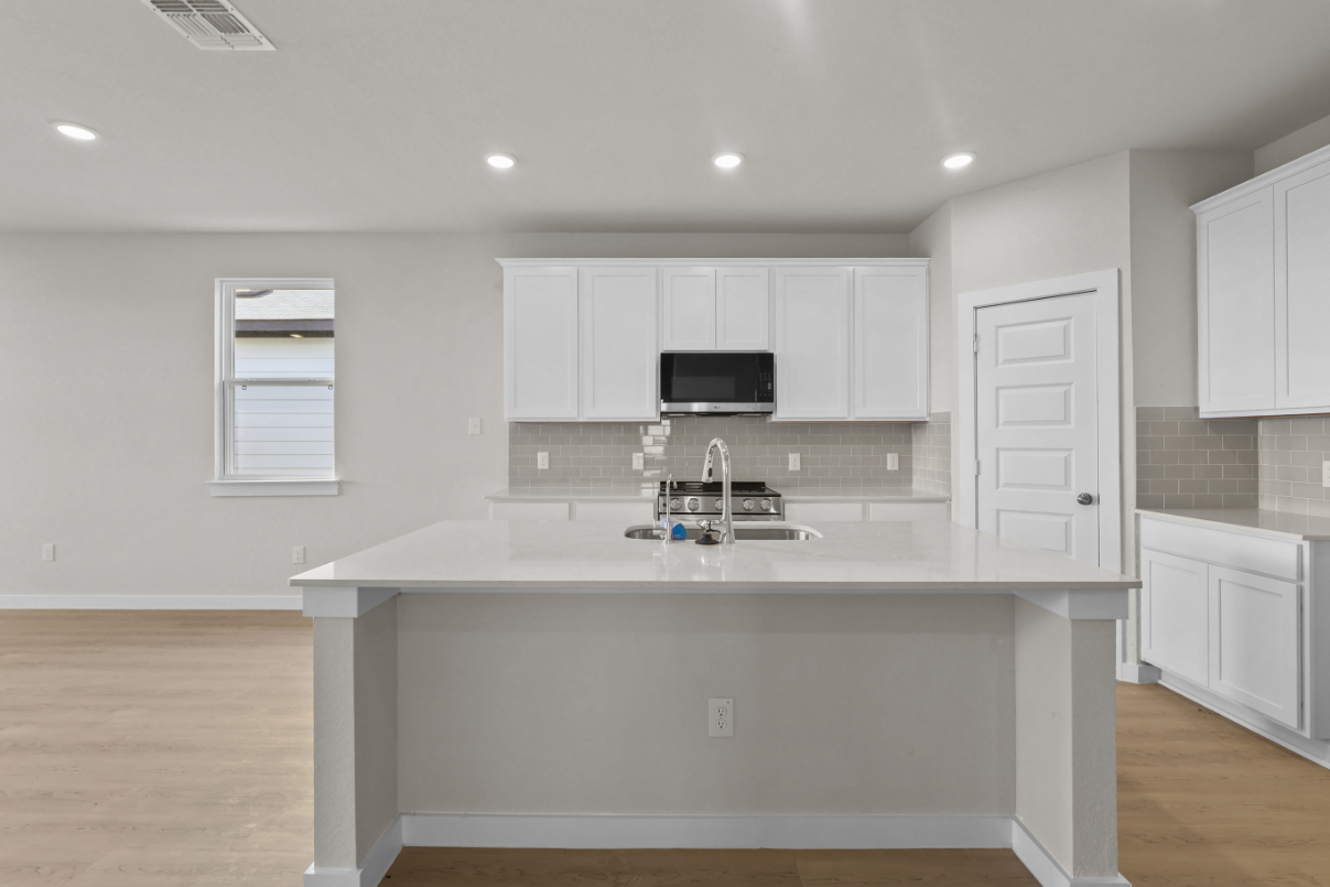 A kitchen with white cabinets.