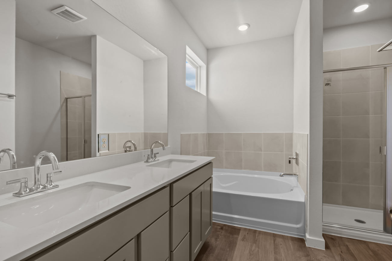 A bathroom with a tub sink and a shower.