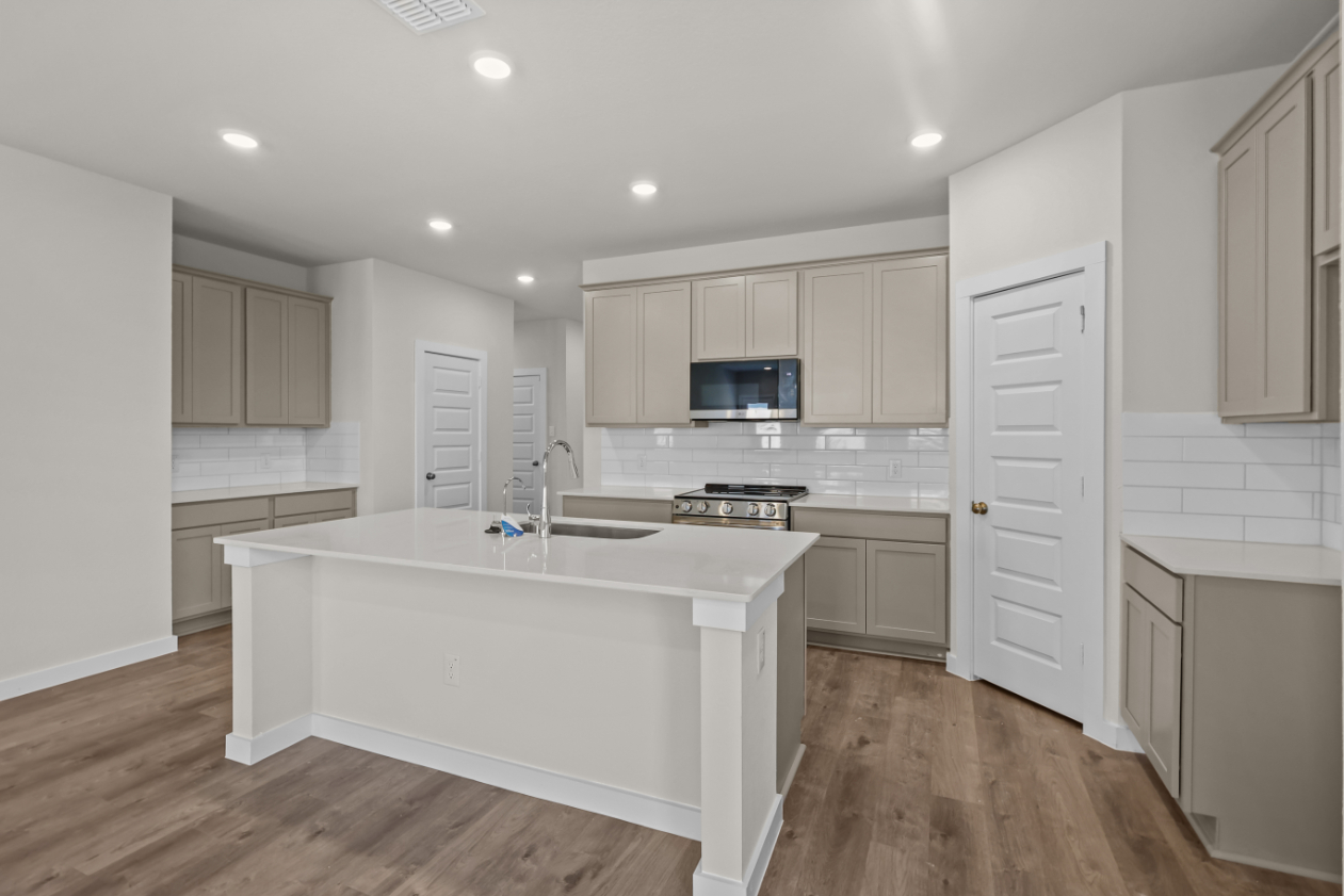 A kitchen with white cabinets.