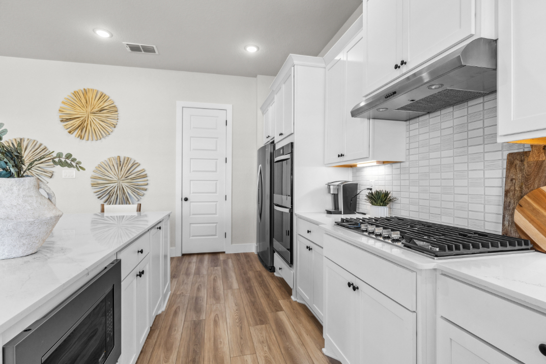 A kitchen with white cabinets.