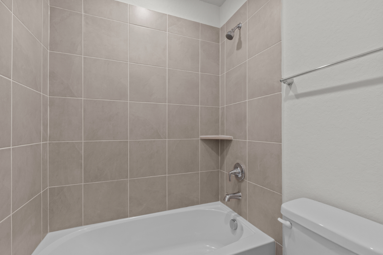 A bathroom with a bathtub and toilet.