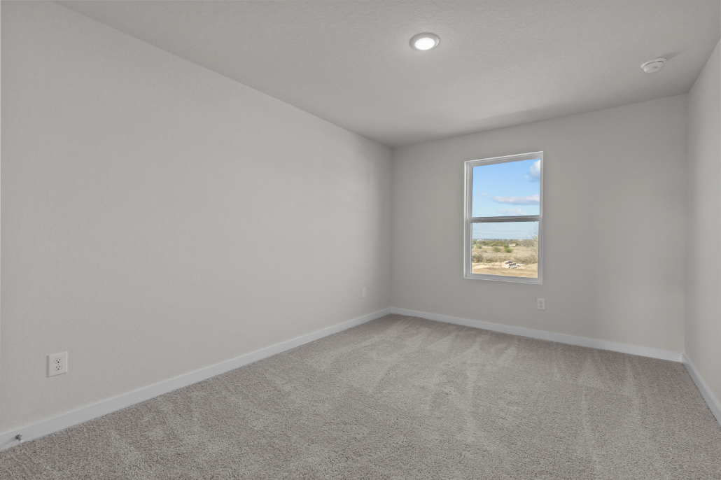 A room with a window and a carpet.