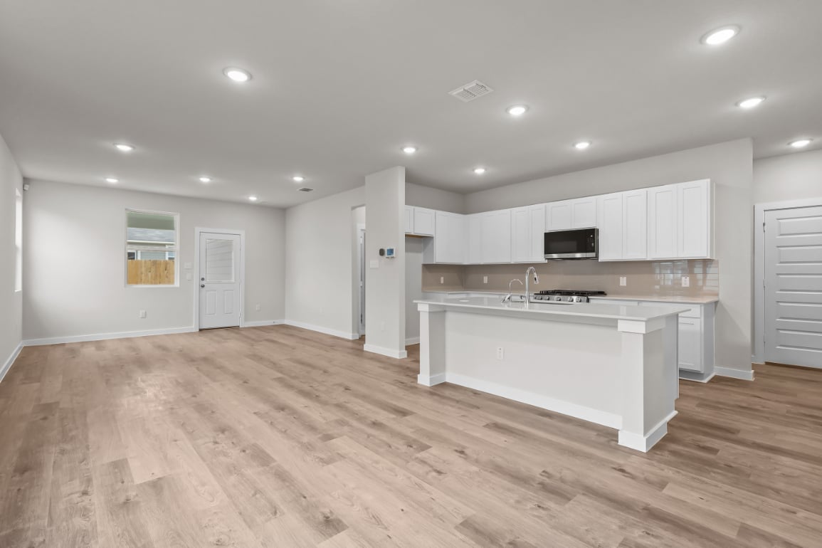 A kitchen with white cabinets.