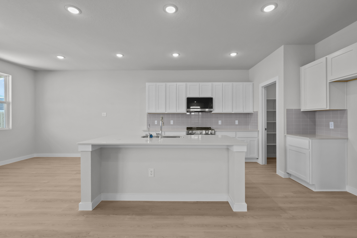A kitchen with white cabinets.