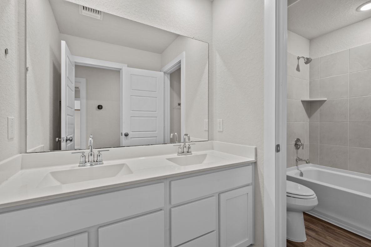 A bathroom with a tub sink and toilet.