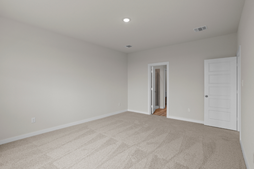 A room with a carpet and a door.