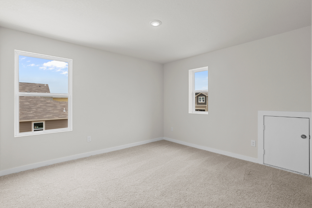 A room with white walls and a door with a window.
