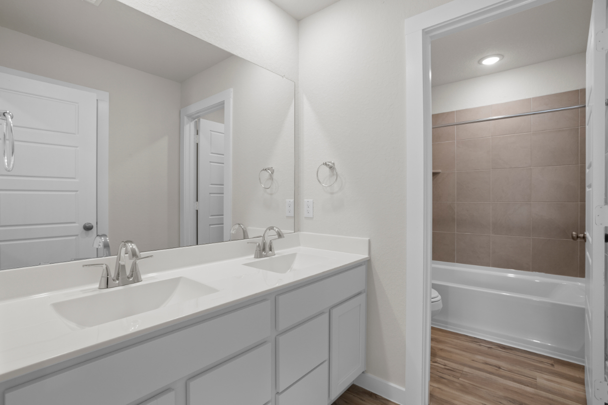 A bathroom with a tub sink and a toilet.