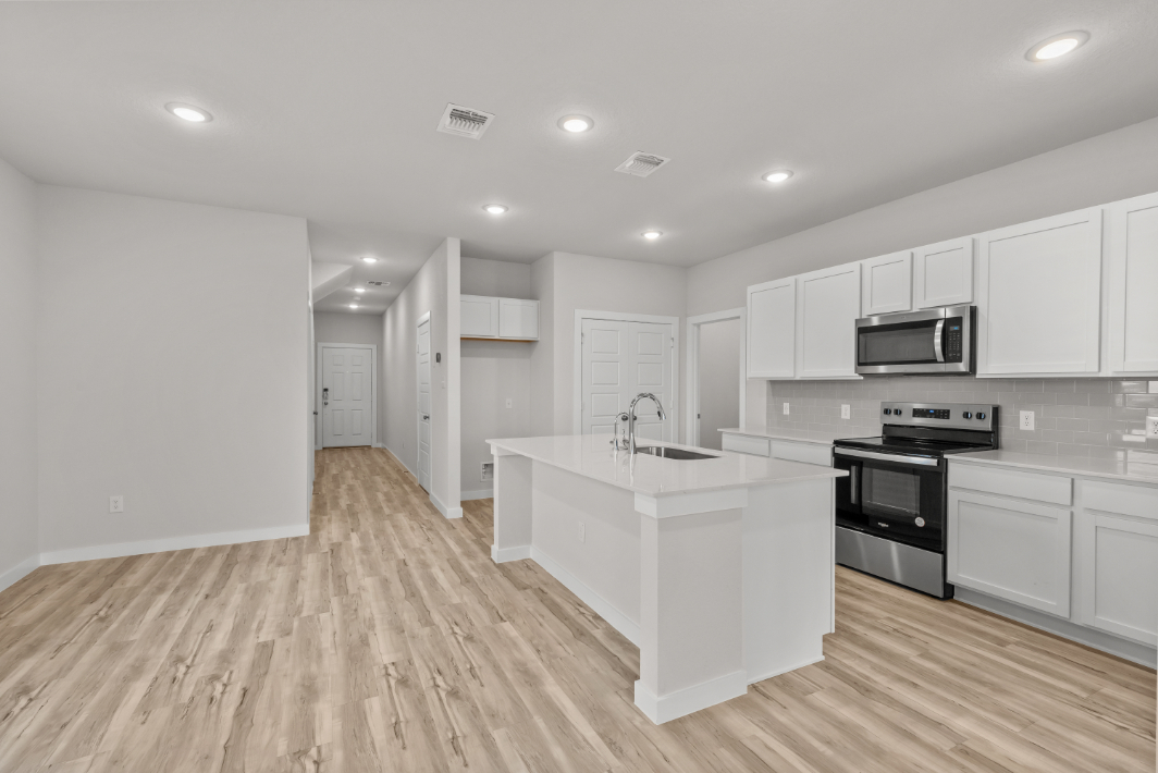 A kitchen with white cabinets.
