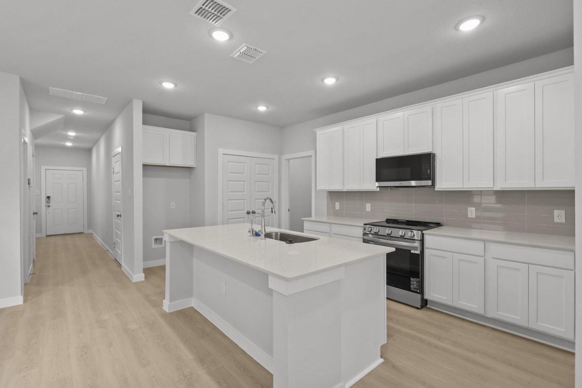 A kitchen with white cabinets.