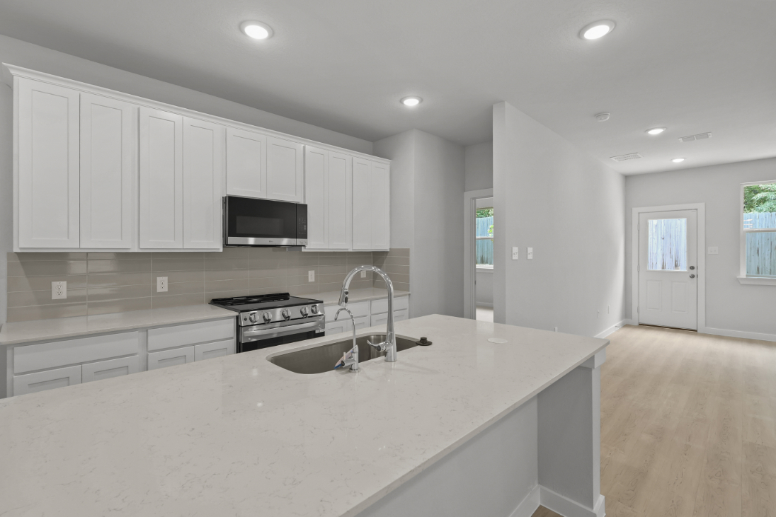 A kitchen with white cabinets.