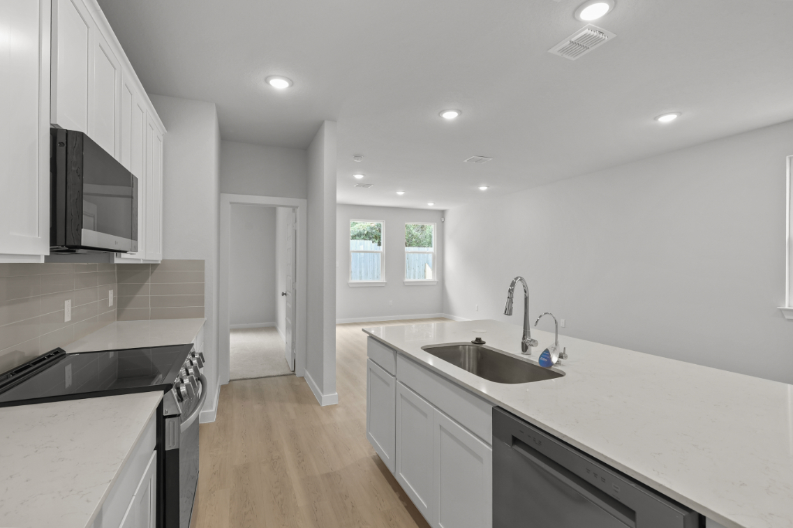 A kitchen with white cabinets.